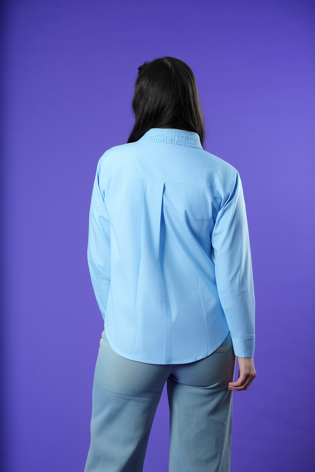Back view of sky blue collared shirt with long sleeves and curved hem