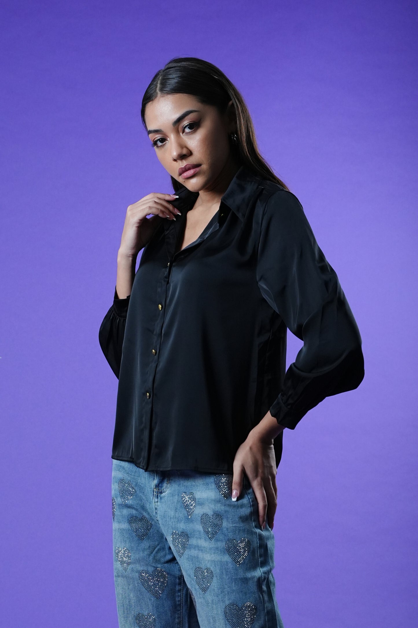 model wearing the Oh My My black shirt and blue jeans against a purple background