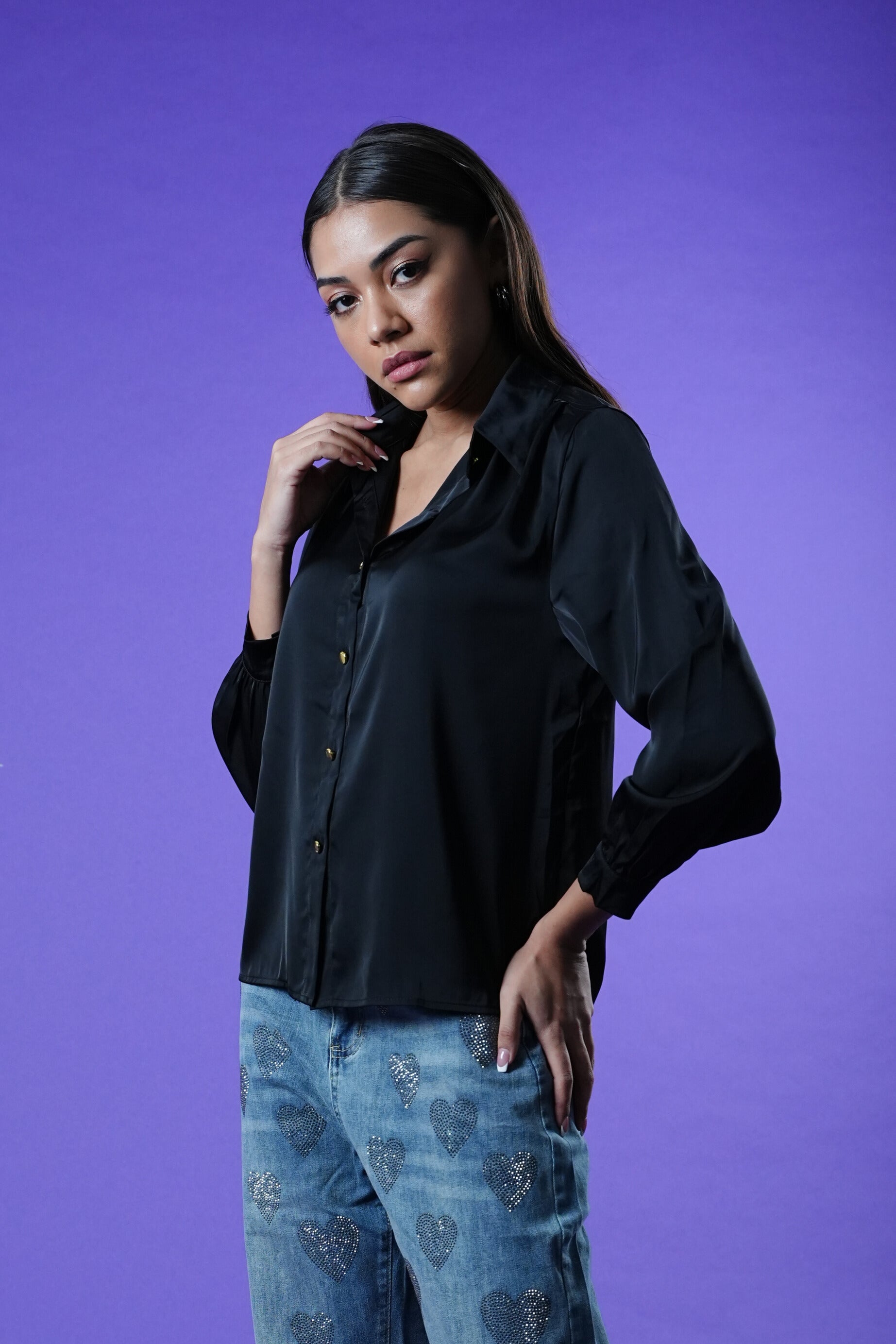 model wearing the Oh My My black shirt and blue jeans against a purple background