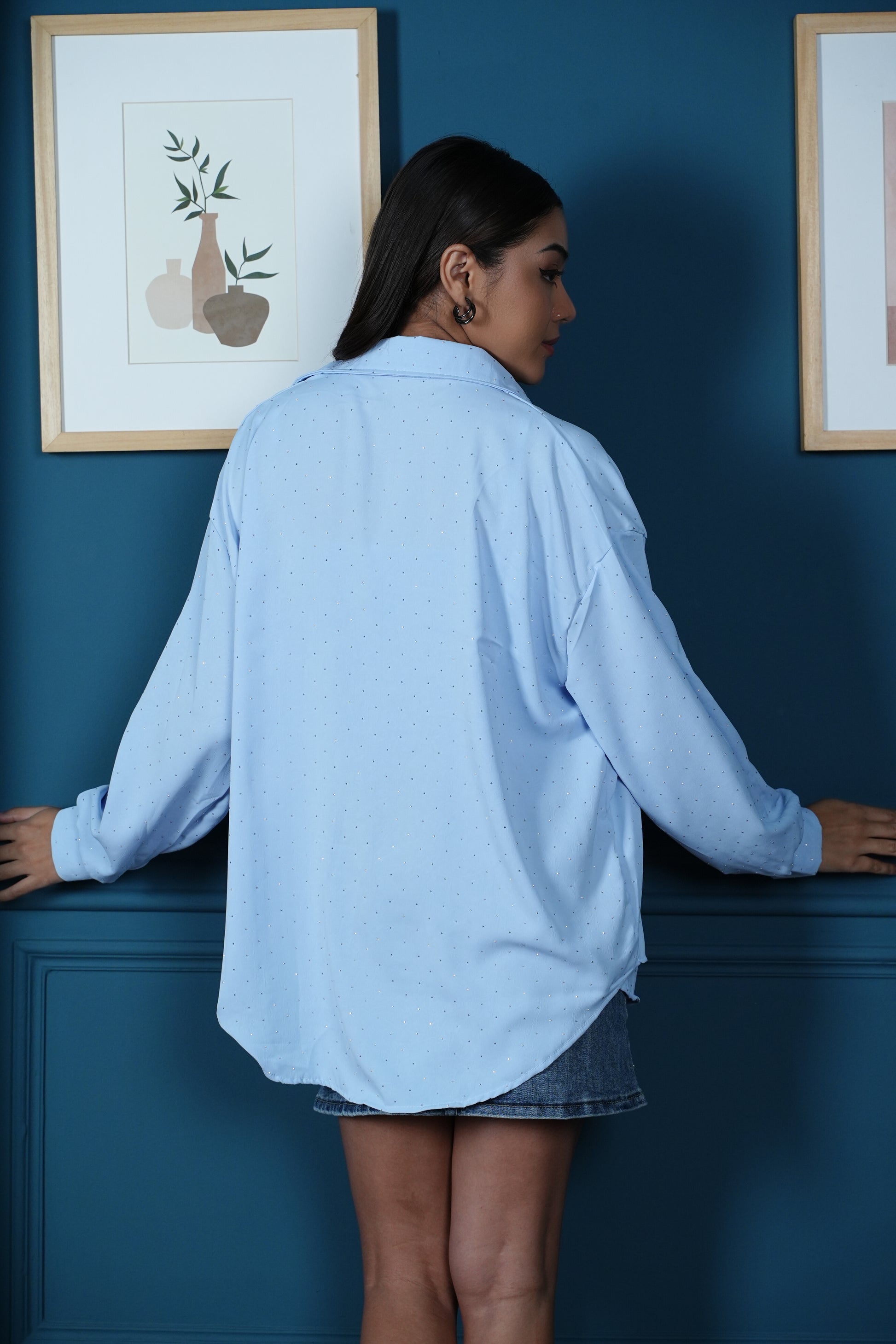 Back view of long oversized studded shirt falling below the hip with curved hemline